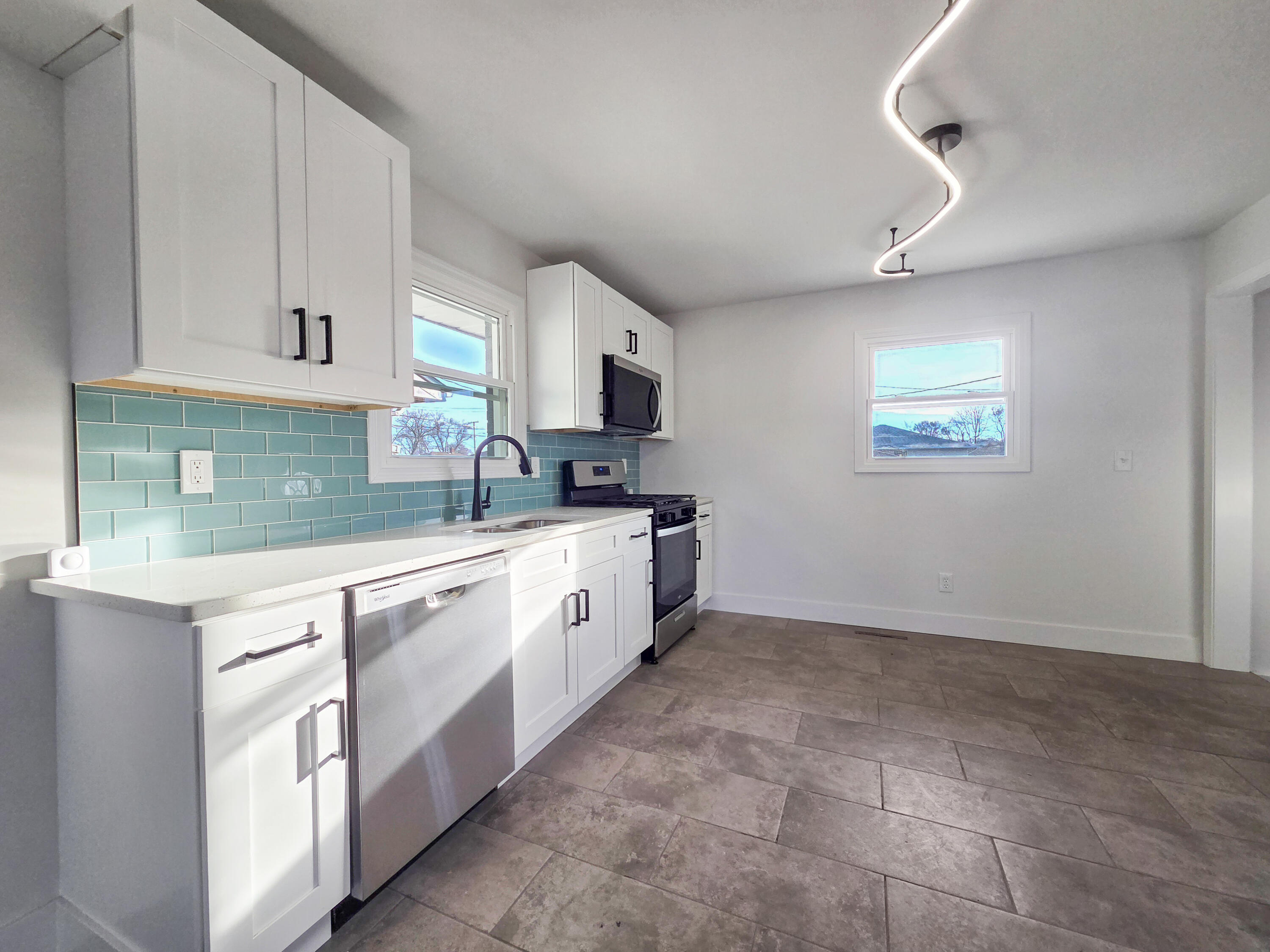 1629 Tennessee Street Gary, IN 46407 - Photo 2 of 26 a large kitchen with stainless steel appliances granite countertop a sink and a stove top oven
