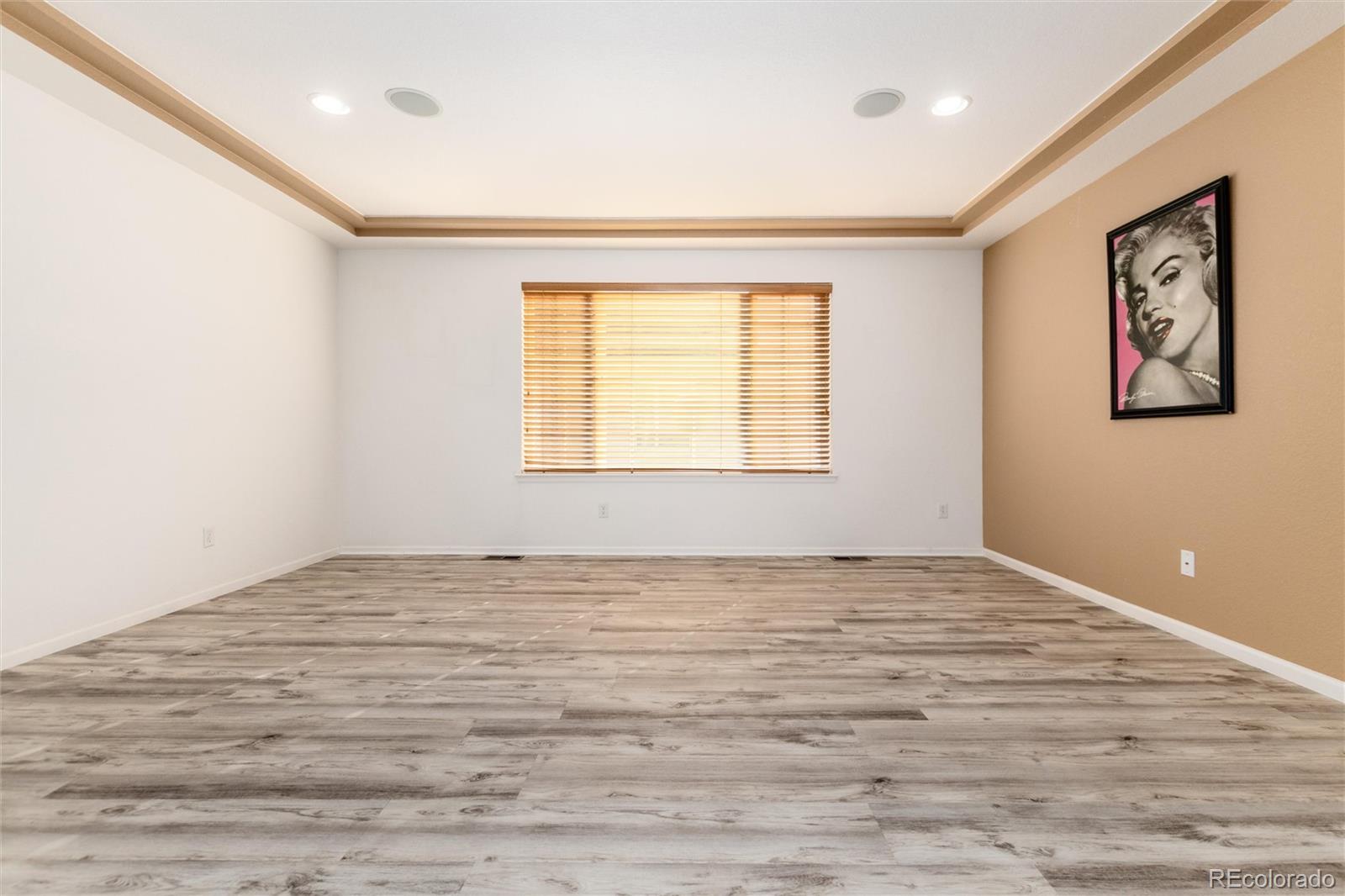 5293 Malaya Street Denver, CO 80249 - Photo 23 of 44 a view of an empty room with window and wooden floor
