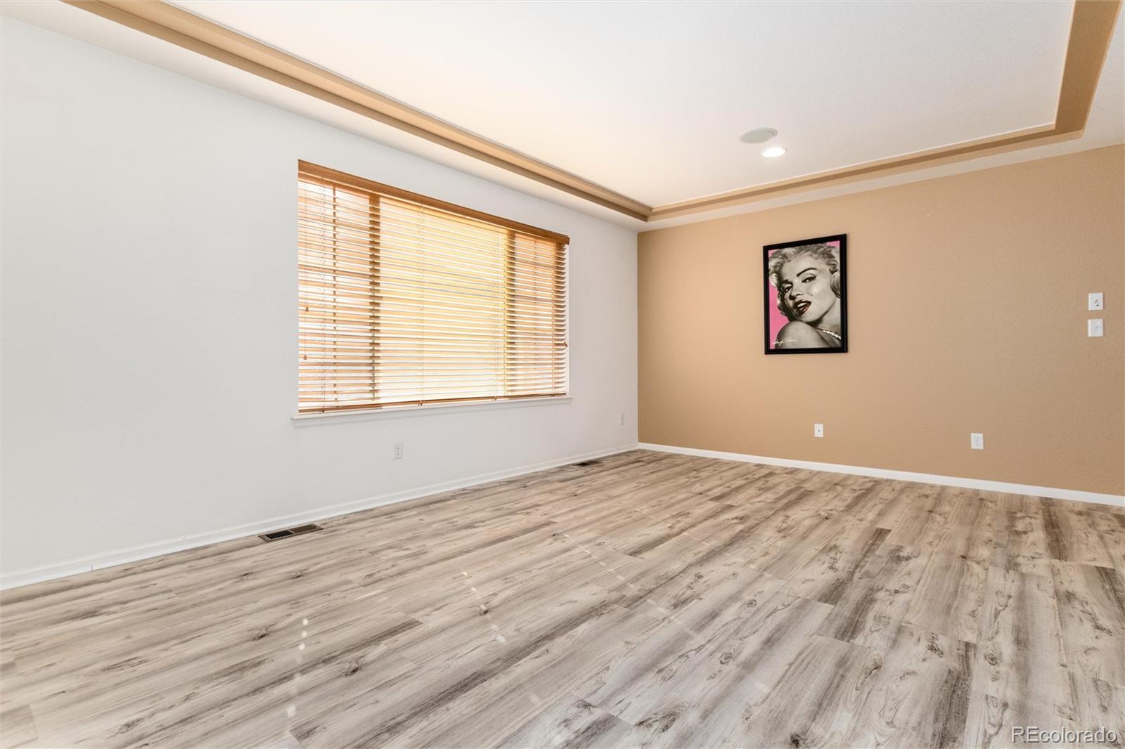 5293 Malaya Street Denver, CO 80249 - Photo 24 of 44 an empty room with wooden floor and windows