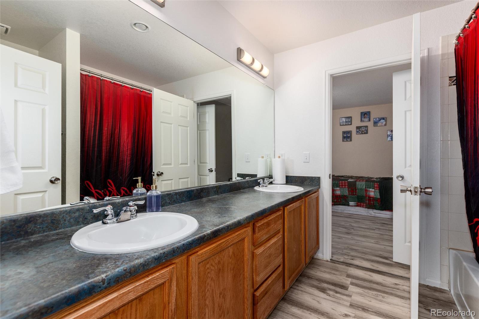 5293 Malaya Street Denver, CO 80249 - Photo 29 of 44 a bathroom with a double vanity sink and a mirror