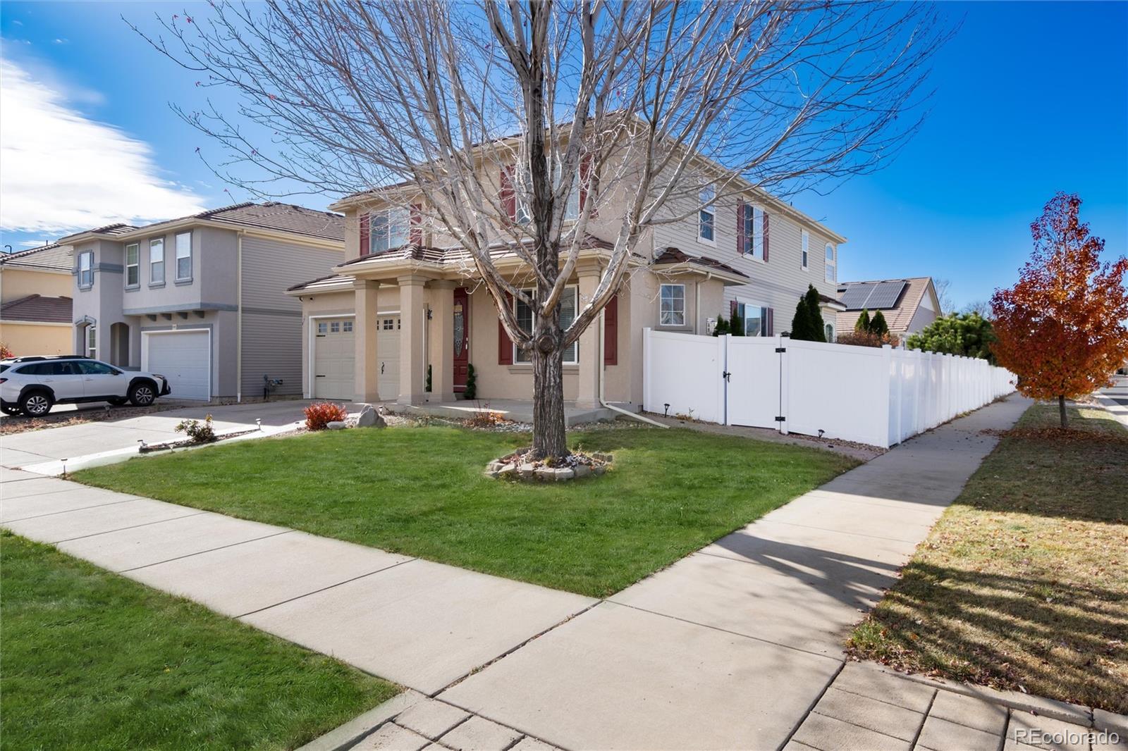 5293 Malaya Street Denver, CO 80249 - Photo 38 of 44 a view of a white house next to a yard with big trees