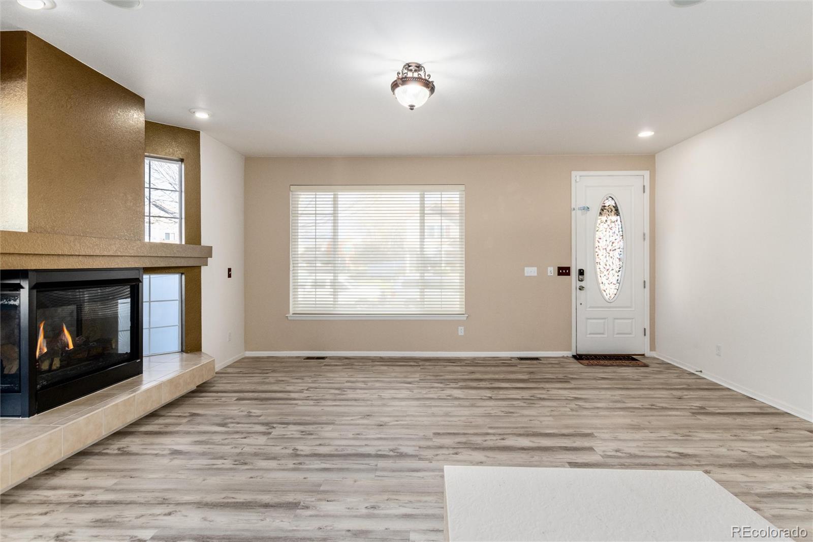 5293 Malaya Street Denver, CO 80249 - Photo 5 of 44 a view of an empty room with window and fire place