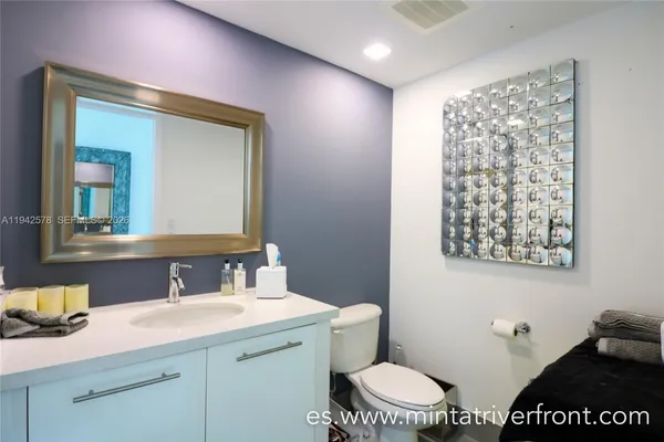 a bathroom with a granite countertop sink a toilet and a mirror