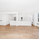 a view of empty room with wooden floor and windows
