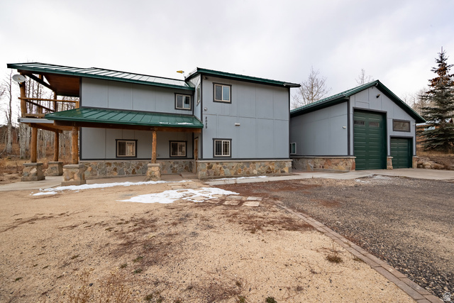 2029 West Tollgate Road Coalville, UT 84017 - Photo 4 of 36 Multi-level residence featuring a covered entry porch with natural wood columns, an upper-level balcony, and a stone-clad foundation
