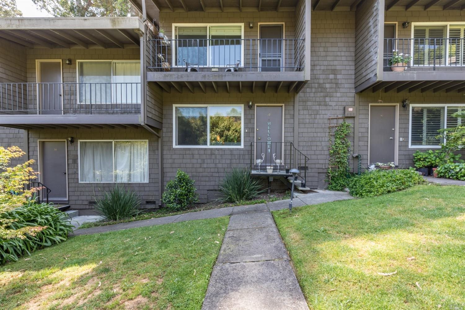1411 Casa Buena Drive, Unit 27 Corte Madera, CA 94925 - Photo 1 of 1 a view of a house with brick walls and a yard with plants