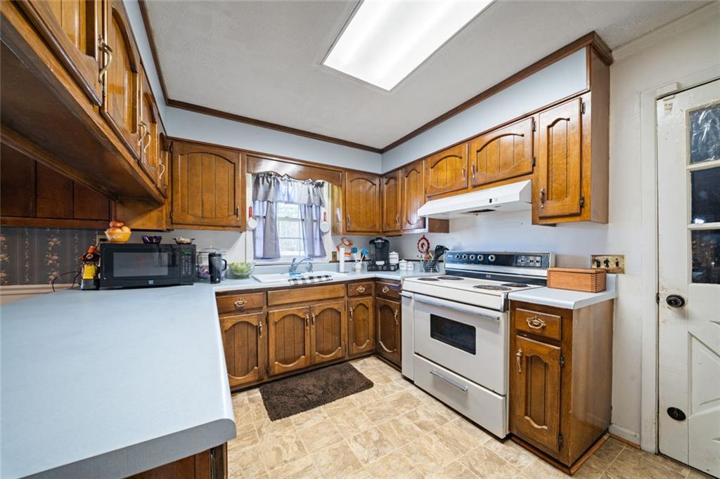 2980 Highway 46 Soperton, GA 30457 - Photo 15 of 27 a kitchen with stainless steel appliances granite countertop a sink a stove and a refrigerator