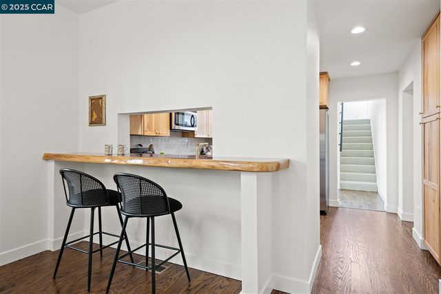 a kitchen with stainless steel appliances granite countertop a stove a sink dishwasher and a microwave oven with white cabinets