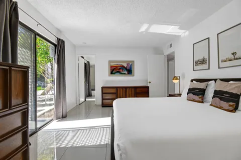 a bedroom with a bed a couch and a window