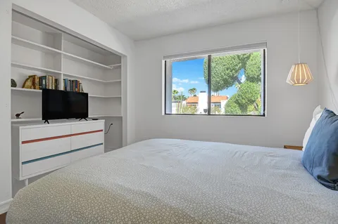 a bedroom with two beds and window