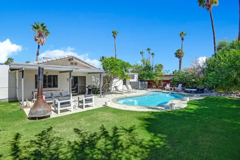 a view of a patio with a table chairs and a backyard