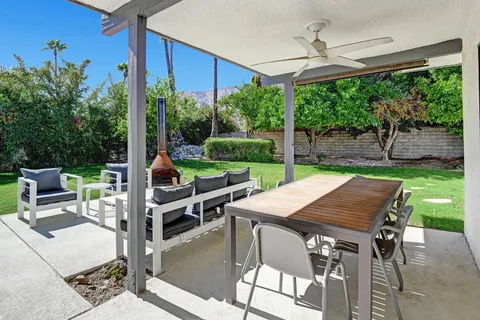 a view of a patio with couches chairs and a yard