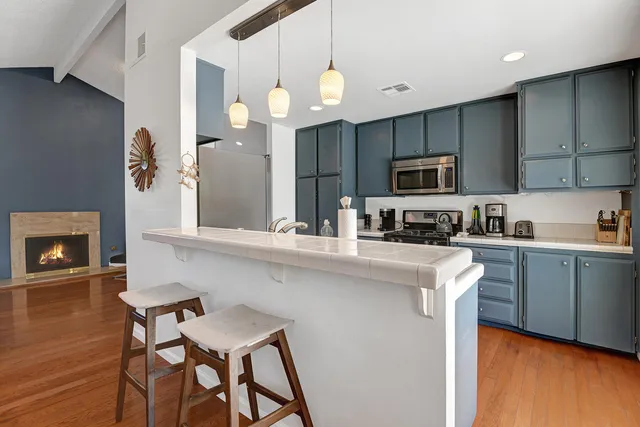 a kitchen with a table chairs microwave and cabinets