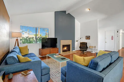 a living room with furniture kitchen view and a fireplace