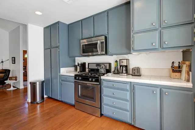 a kitchen with stainless steel appliances granite countertop a stove a sink and a refrigerator