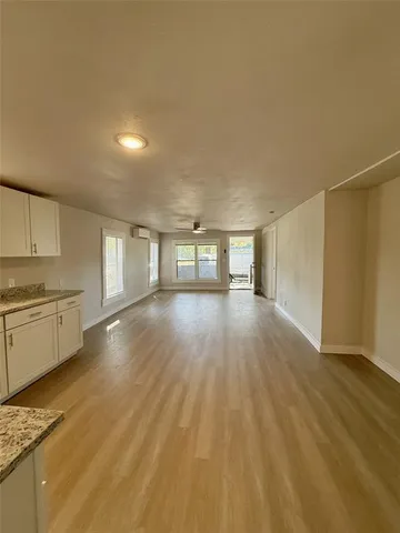 a view of a kitchen with wooden floor and electronic appliances