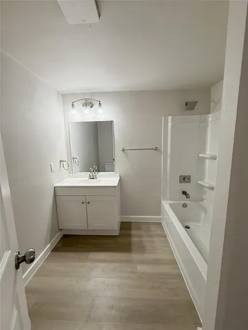 a bathroom with a bathtub sink mirror and vanity