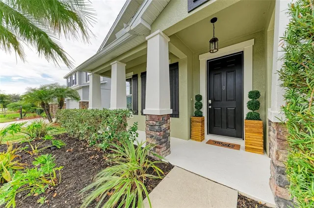 a kitchen with stainless steel appliances granite countertop a sink a stove a refrigerator and white cabinets