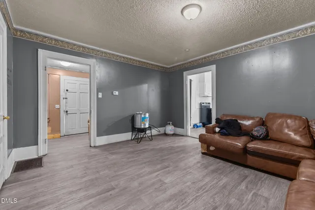 a living room with furniture and a wooden floor