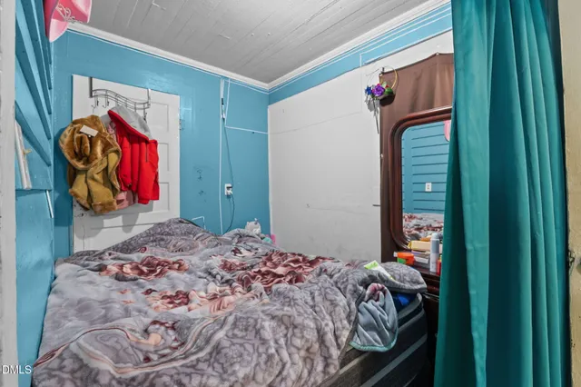 a bedroom with a bed and a painting on the wall