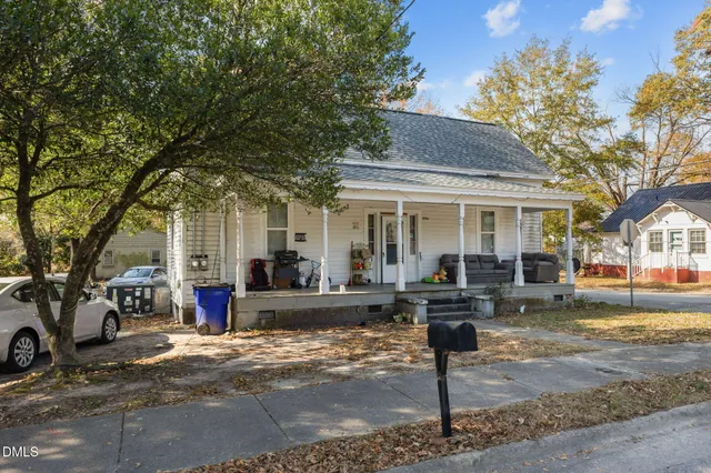 a front view of a house with a tree