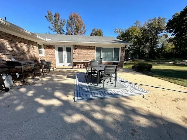 a view of a patio with table and chairs with wooden floor and fence