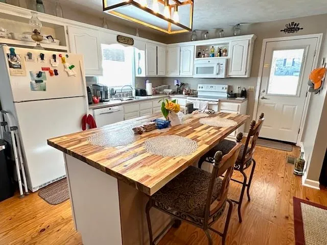 a kitchen with stainless steel appliances granite countertop a table chairs and a refrigerator