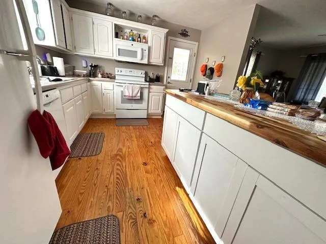 a kitchen with white cabinets and sink