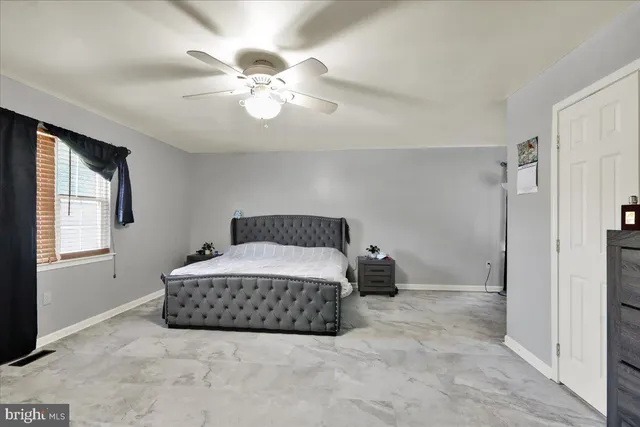 a spacious bedroom with a bed and window