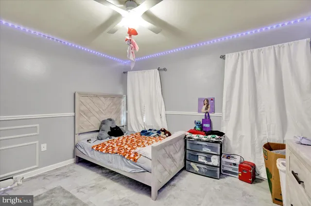 a bedroom with furniture and a chandelier fan