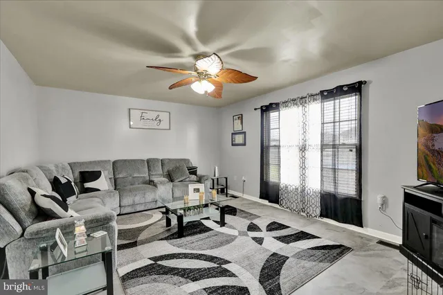 a living room with furniture a flat screen tv and a window