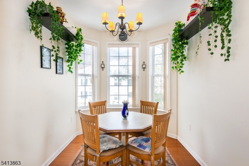 9 Cliff Road, Unit D3 Woodland Park, NJ 07424 - Photo 11 of 25 a dining room with furniture a potted plant and a chandelier