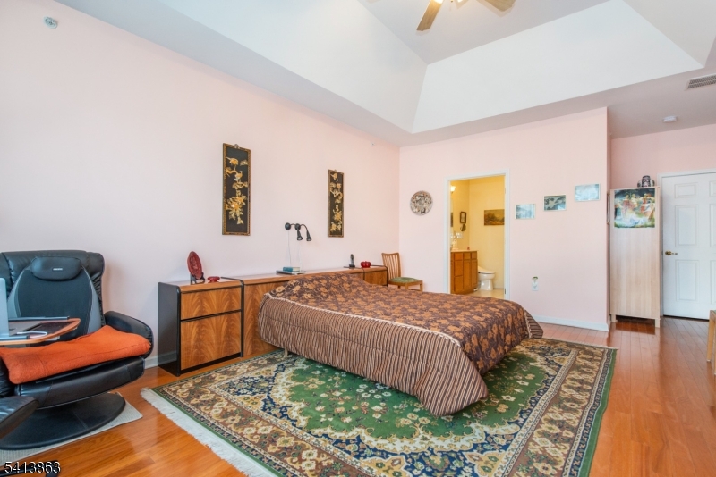 9 Cliff Road, Unit D3 Woodland Park, NJ 07424 - Photo 3 of 25 a bedroom with a bed and wooden floor
