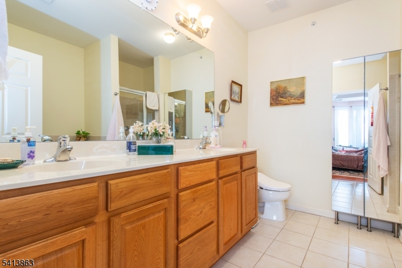 9 Cliff Road, Unit D3 Woodland Park, NJ 07424 - Photo 4 of 25 a bathroom with a double vanity sink toilet and a mirror