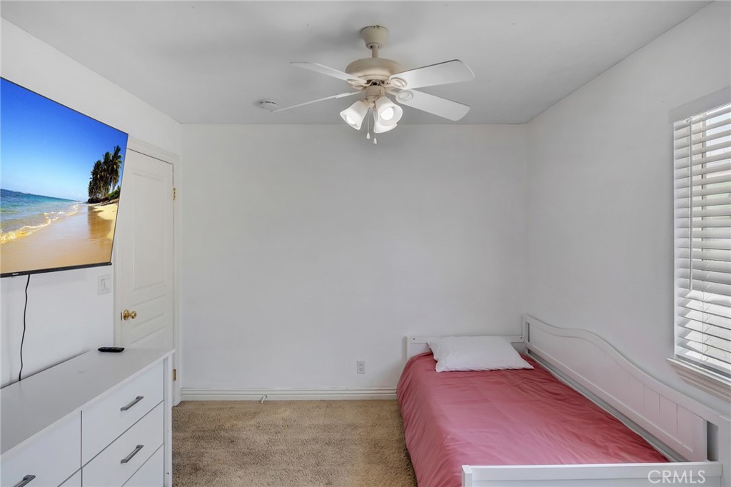 14952 Rivers Edge Road Helendale, CA 92342 - Photo 23 of 33 a bedroom with a bed and a chandelier fan
