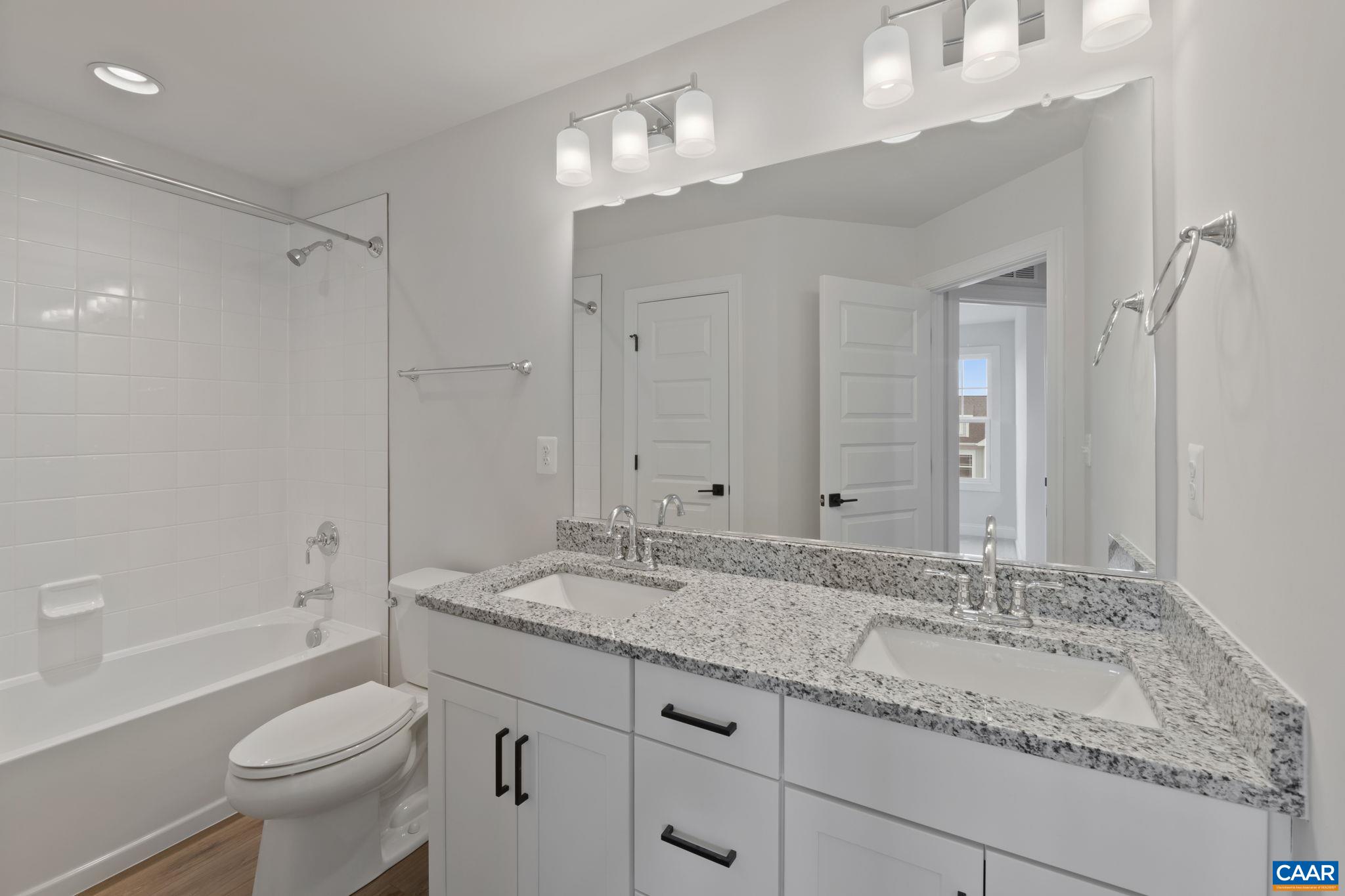 47 Marcella Street Charlottesville, VA 22911 - Photo 35 of 48 a bathroom with a granite countertop sink a toilet a mirror a bathtub and shower
