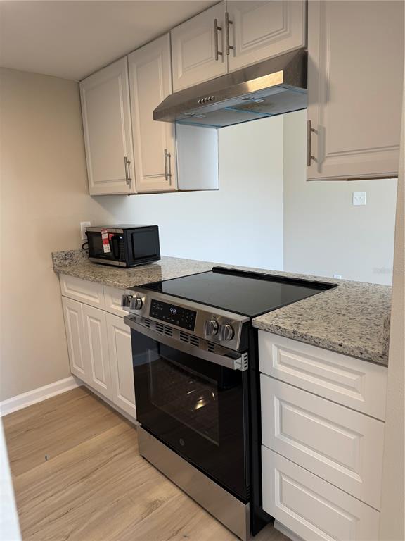 5521 Bay Boulevard, Unit 105 Port Richey, FL 34668 - Photo 5 of 15 a kitchen with granite countertop a stove and a sink