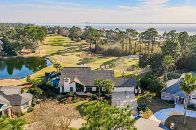 an aerial view of residential houses with outdoor space and ocean view