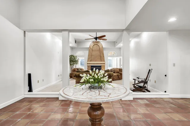 a living room with furniture a fireplace and a chandelier