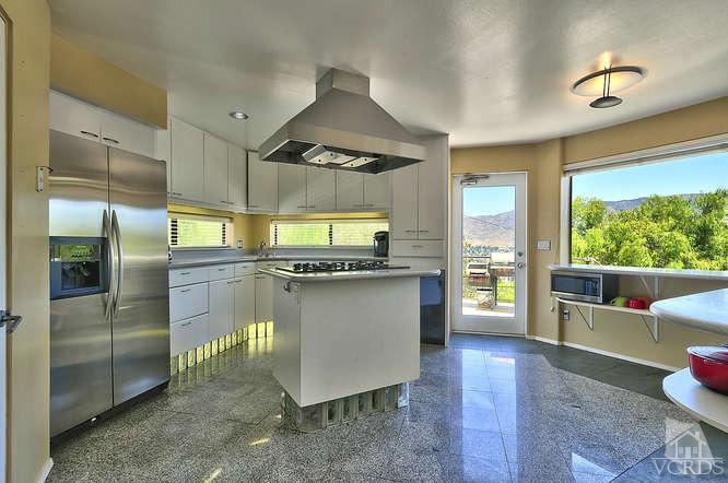 5940 Hilltop Road Simi Valley, CA 93063 - Photo 10 of 34 a kitchen with a refrigerator and wooden cabinets