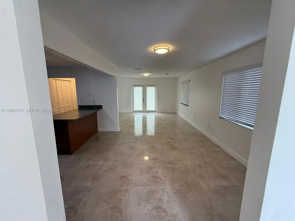 an empty room with windows and fireplace