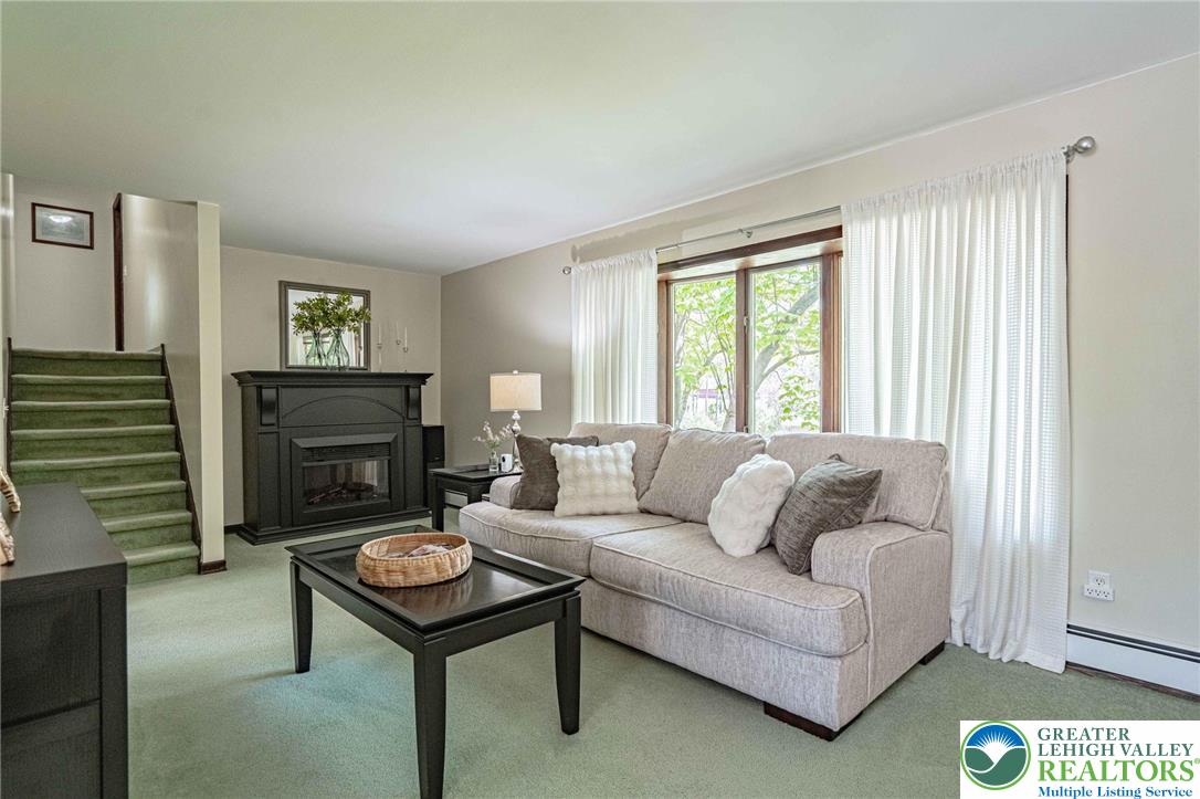 3857 Friedens Road Slatington, PA 18080 - Photo 35 of 75 This inviting living area features a charming fireplace and bright window, creating a cozy and airy atmosphere.