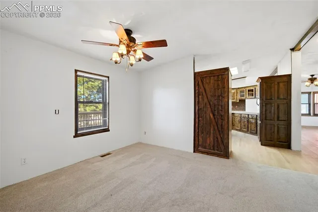 a view of a livingroom with a furniture ceiling fan and a window