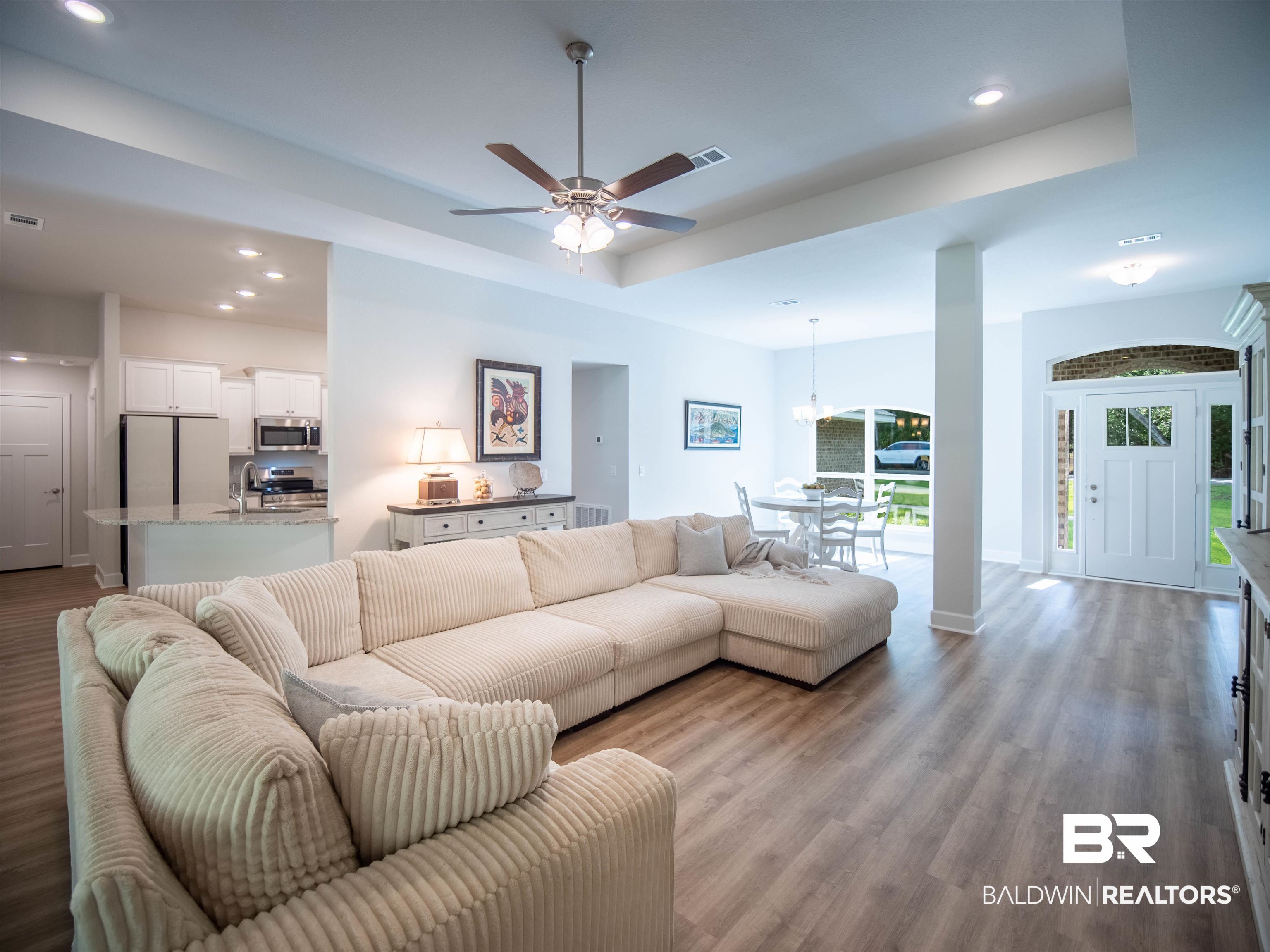 12646 Michigan Avenue Elberta, AL 36530 - Photo 8 of 47 Living room featuring recessed lighting, ceiling fan, a raised ceiling, wood finished floors, and a chandelier