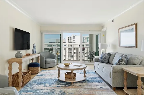 a kitchen with stainless steel appliances kitchen island granite countertop a refrigerator a sink a stove and chairs