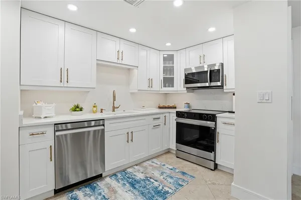 a kitchen with stainless steel appliances a stove a sink and a microwave