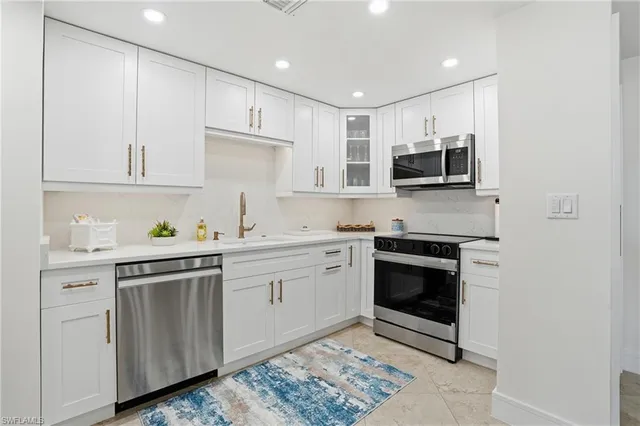 a kitchen with stainless steel appliances a stove a sink and a microwave