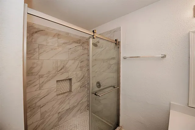 a bathroom with double vanity sink and shower