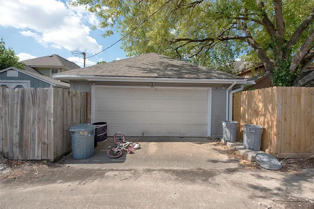 a side view of a house with a small yard and a large tree