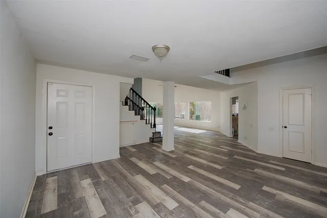 a view of a livingroom with wooden floor and stairs